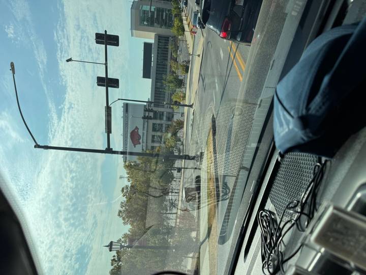 Blurry view through car windshield of city street and stadium sign