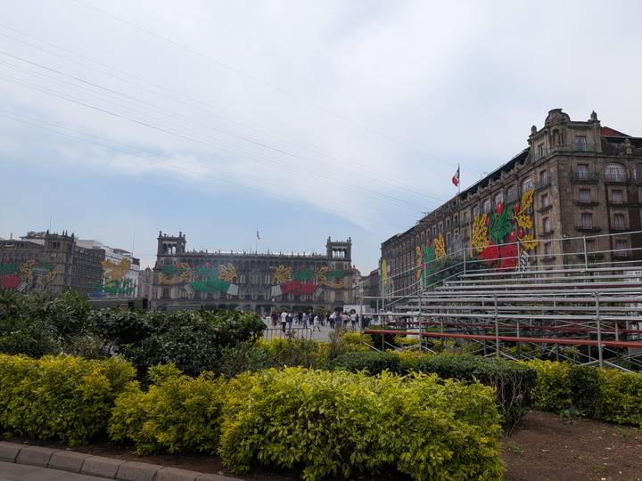 Zócalo buildings adorned with colorful Independence Day decorations beside temporary stands