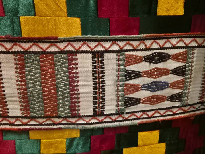 Detail of traditional woven textile featuring geometric patterns and rich colors.
