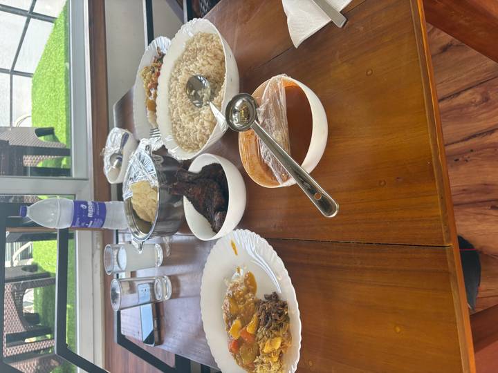 Simple home-style Indian lunch spread on a wooden table with rice, curry, and grilled meat.