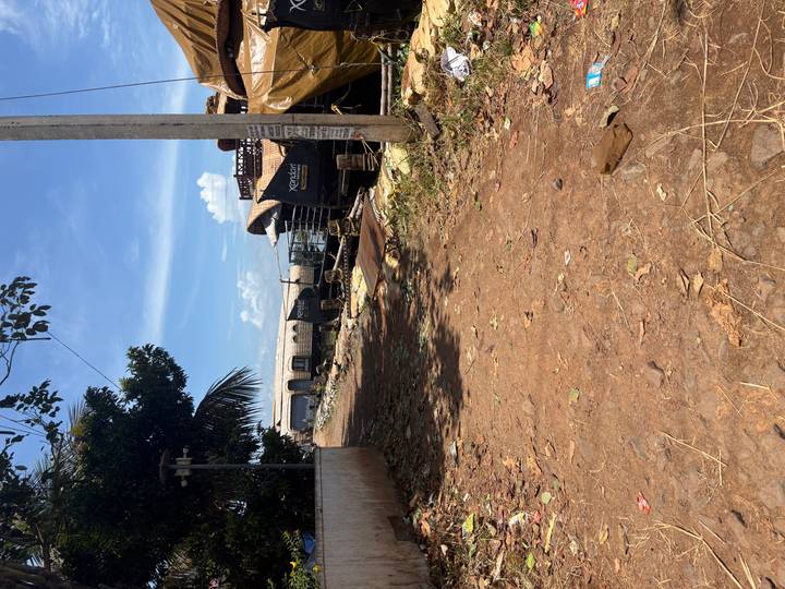 Dusty shore yard with multiple houseboats under repair and scattered debris on a hot day.