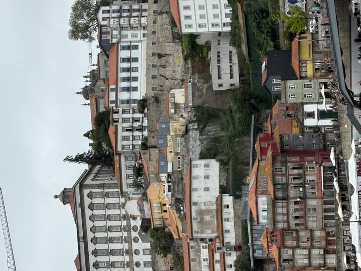 Tall, colourful riverfront buildings cascade down Porto’s hillside toward the Douro River on a cloudy day.