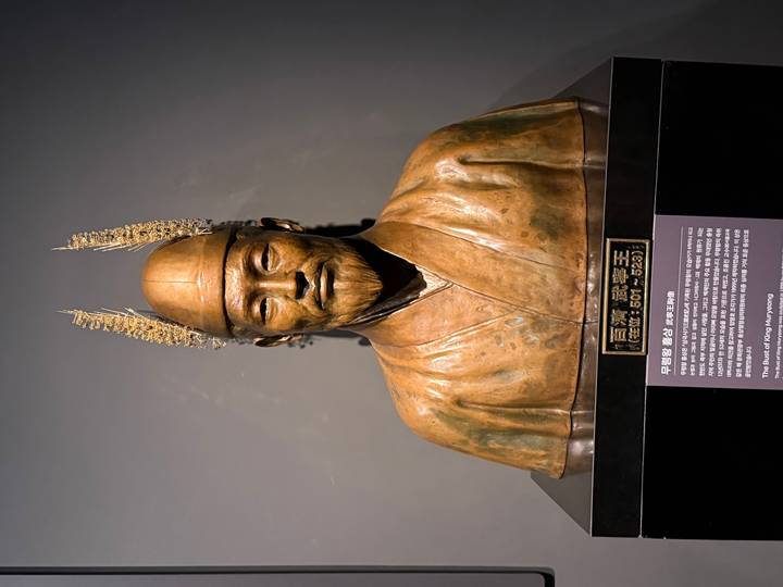 Bronze bust of King Muryeong displayed in a museum with Korean label underneath.