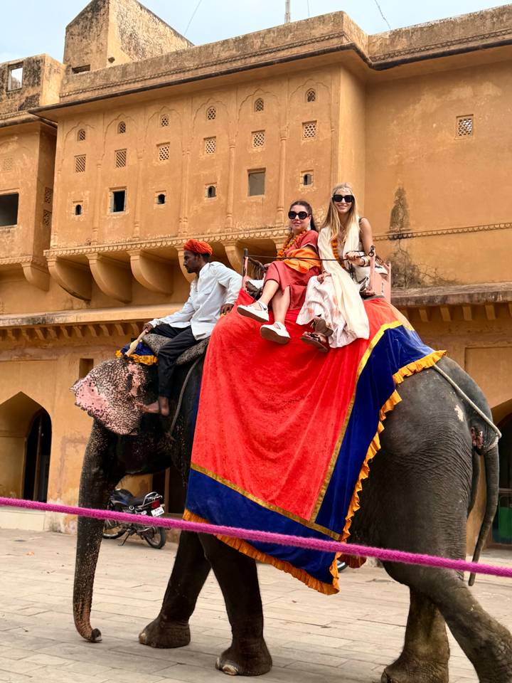 Travellers riding a decorated elephant up the ramparts of Amber Fort.