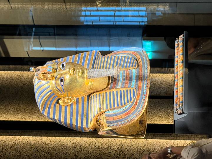 Close-up of Tutankhamun’s gold funerary mask displayed in a museum showcase.