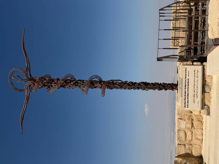 Bronze Serpent sculpture spirals skyward on Mount Nebo with an expansive Jordan valley backdrop.