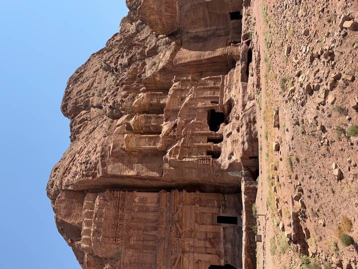Weather-sculpted rock façades and openings at Petra’s lesser-visited cliff dwellings.