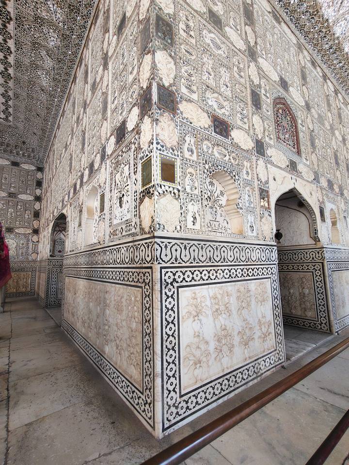 Ornate mirrored walls and marble panels of the Sheesh Mahal palace interior.