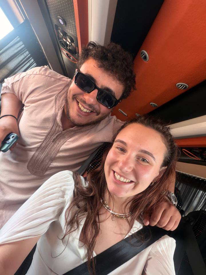 Smiling travellers take a selfie inside a tour vehicle.