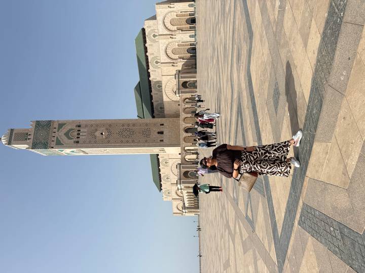 Traveler poses in wide plaza before Casablanca’s Hassan II Mosque.