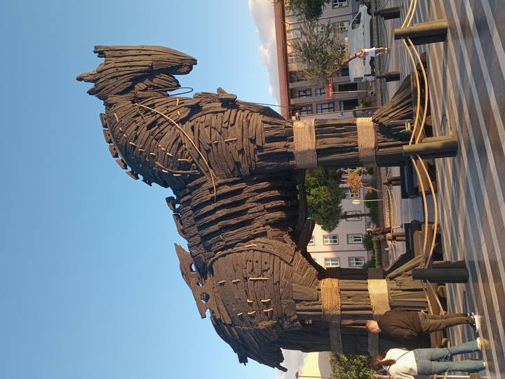 Large replica of the wooden Trojan Horse on a public square at Çanakkale under warm evening light.