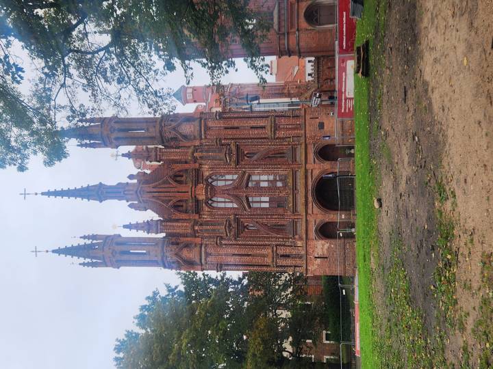 Gothic red-brick St. Anne's Church with slender spires rising against an overcast sky.