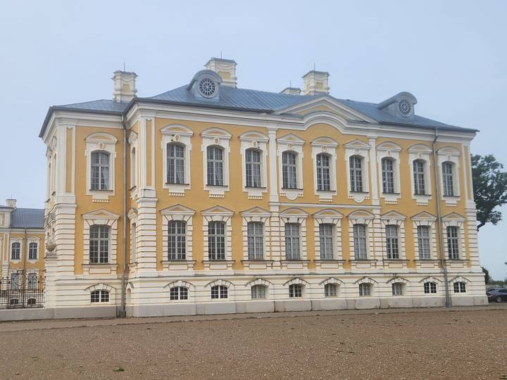 Elegant yellow Baroque palace with white pilasters and tall windows.