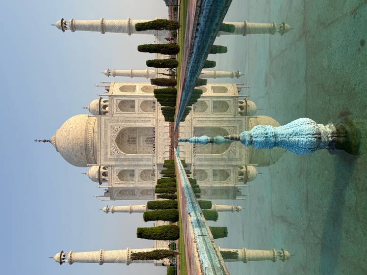 The Taj Mahal gleams in morning light, perfectly reflected in its long garden pool.