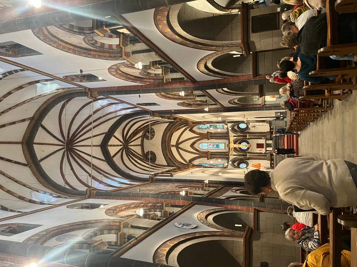 High vaulted interior of a historic church adorned with arches and frescoes