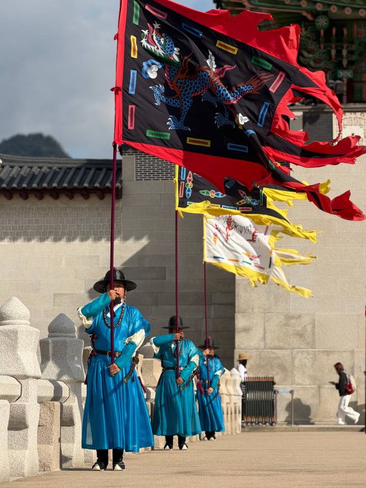 Palace guards wave colourful flags during a ceremonial march.