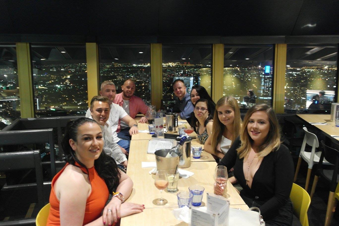A group of people dining in a cityscape setting.