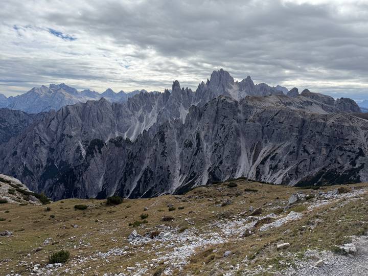 Dramatic grey limestone pinnacles of the Dolomites under a moody cloud-filled sky.
