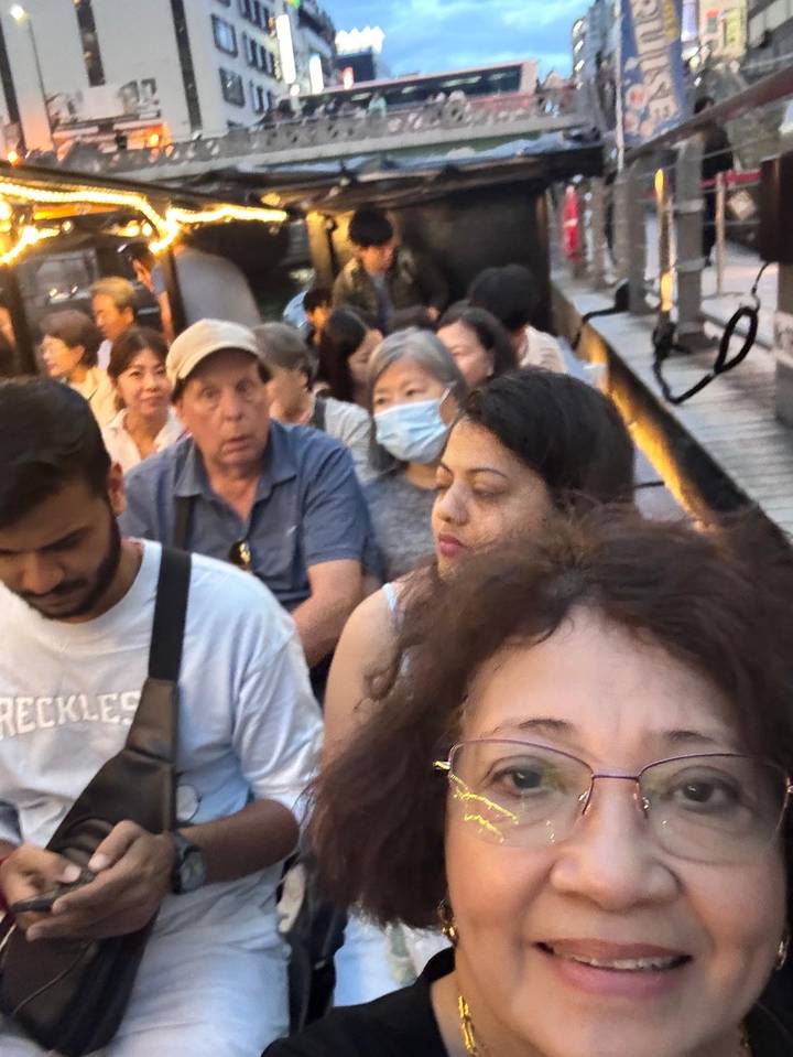 Crowded close-up selfie of passengers on public transport, some wearing masks.