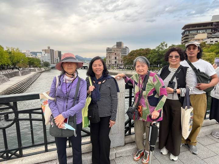 Group stands on bridge overlooking Hiroshima’s Peace Memorial Park and Atomic Dome.