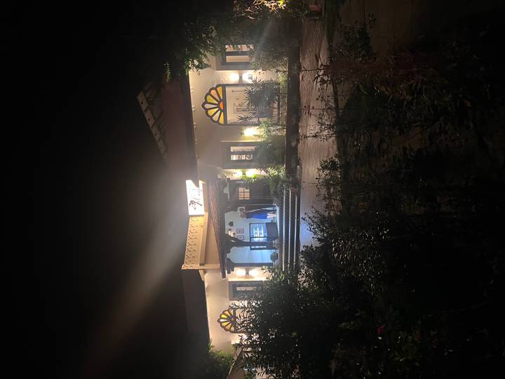 Nighttime view of a lit lodge entrance surrounded by foliage