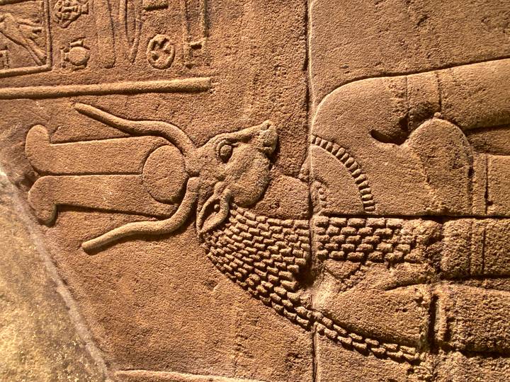 Close-up of an ancient Egyptian relief carving depicting a goddess with elaborate headdress.