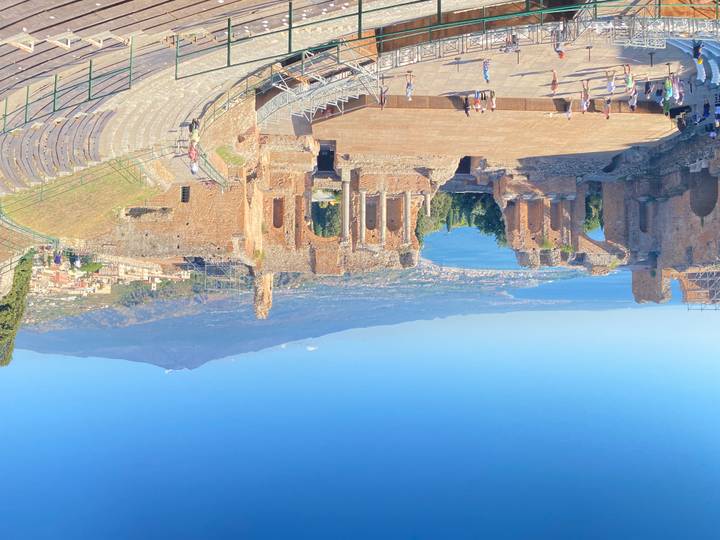 Panoramic of the ancient Greek Theatre of Taormina with Mount Etna beyond the bay.