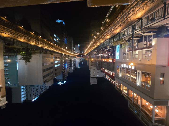 Night lights reflect along Osaka’s Dotonbori canal flanked by lively restaurants and high-rise buildings.