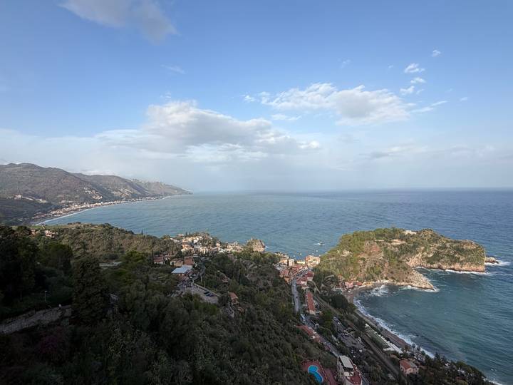 Panoramic coastal view of Sicilian hillside towns and expansive blue Mediterranean.