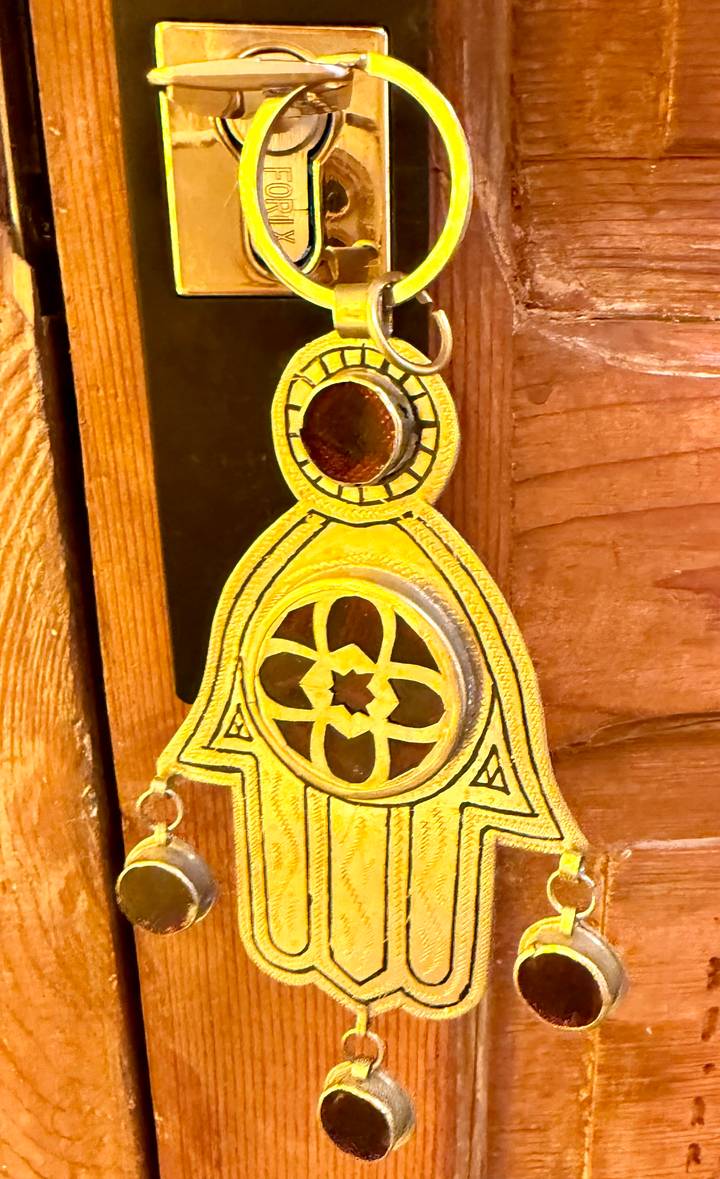 Close view of a decorative golden door knocker against carved wooden panels.