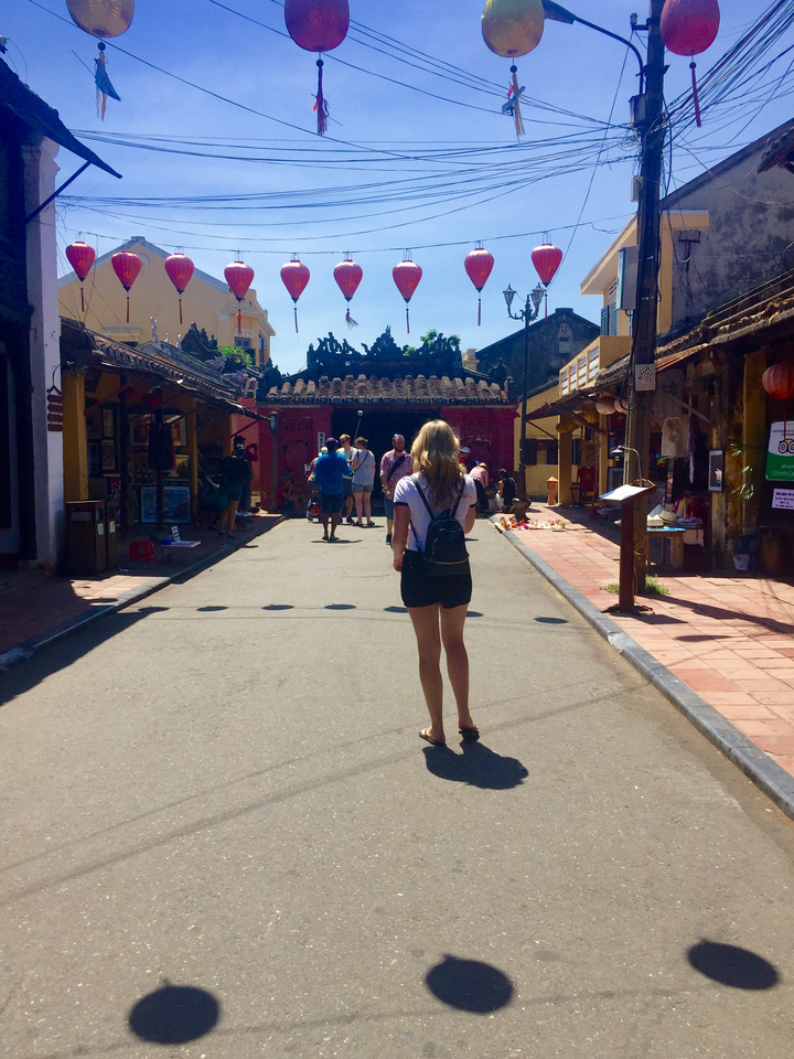 Tourist walking down a vibrant street.