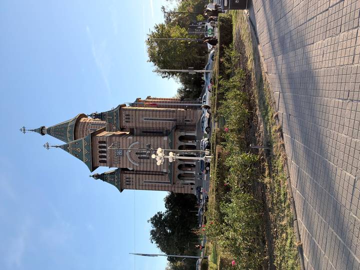 Grand Orthodox cathedral with ornate spires and patterned brickwork against a clear sky.
