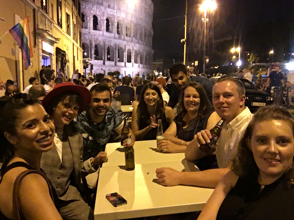 Group dining outdoors at night near a historic building.