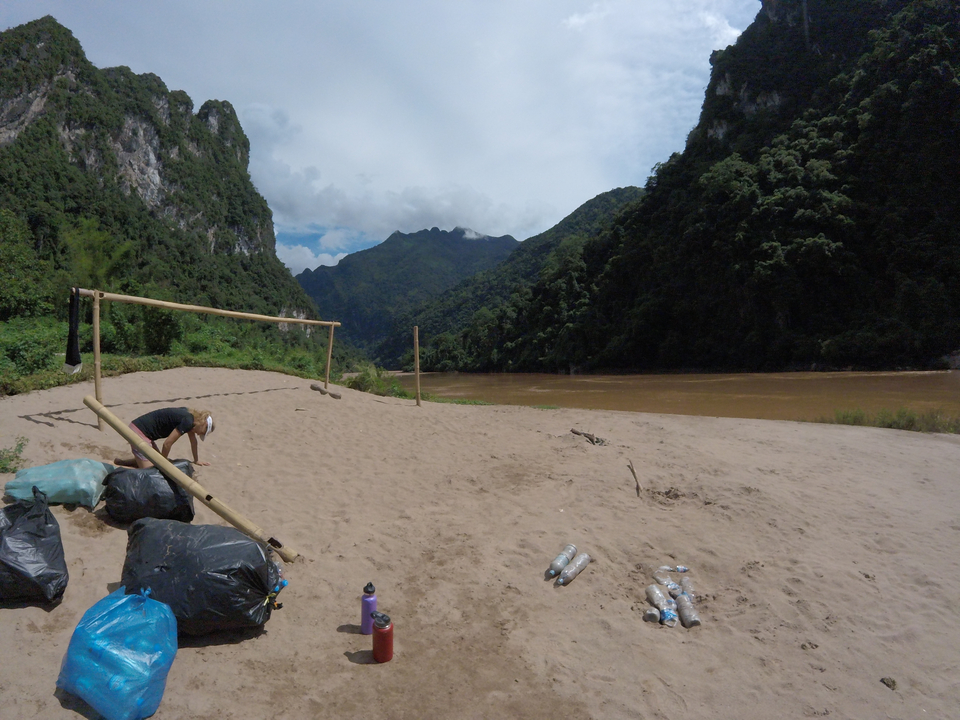 Beach volleyball setup by a river with mountains.