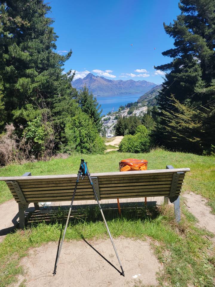 Une image pivotée d'un banc avec des montagnes au loin.
