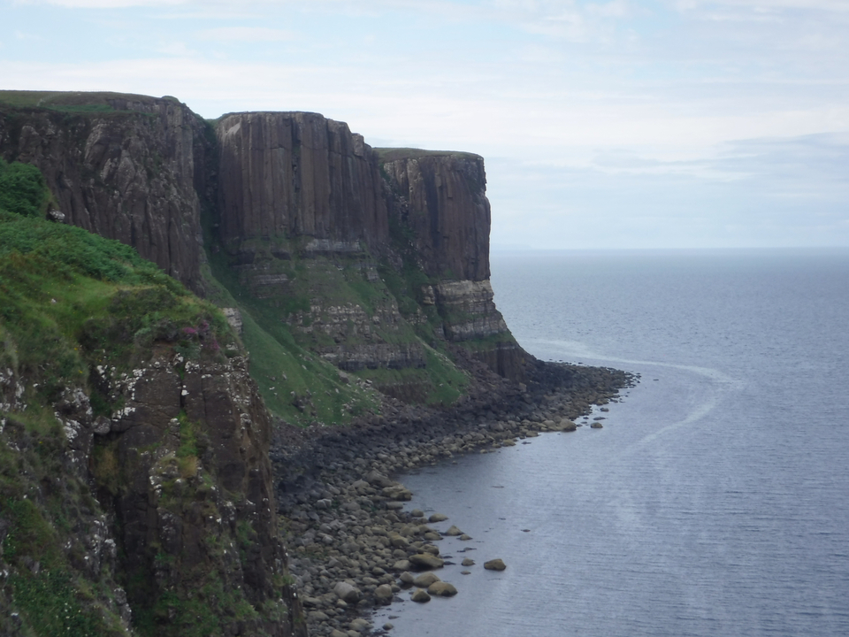 Steep cliffs along the coastline under cloudy skies.
