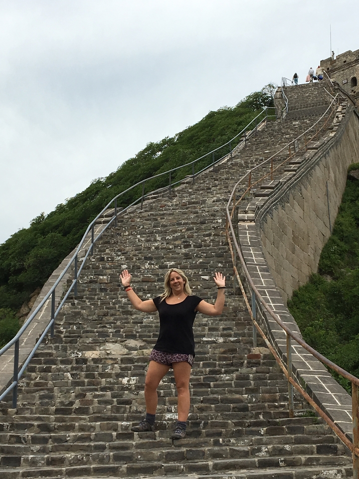 Femme debout sur l'escalier escarpé d'une grande structure.