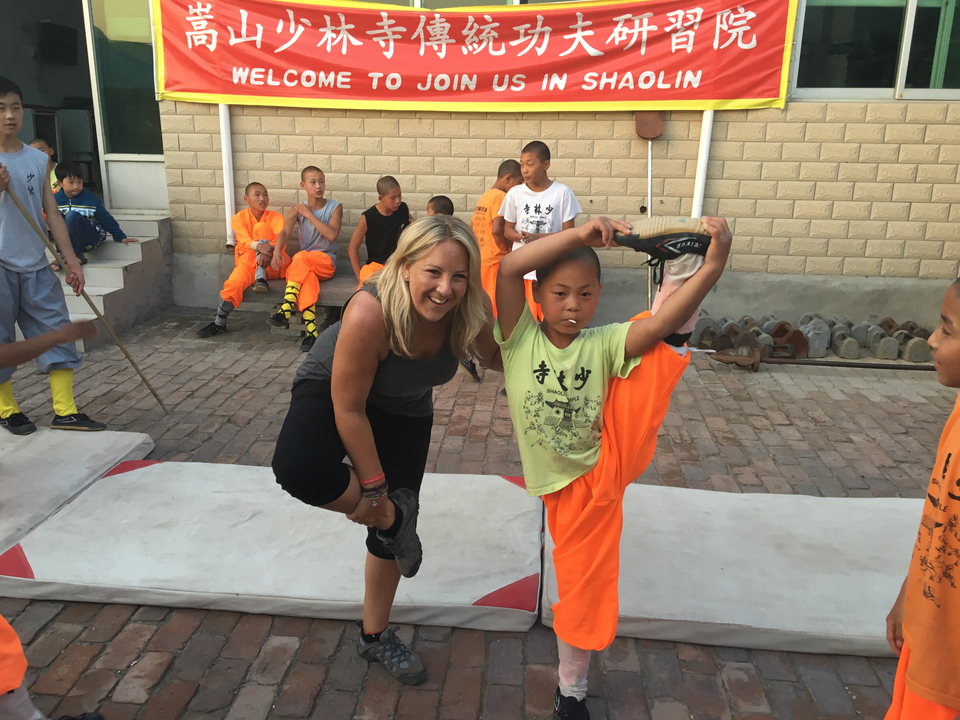 Femme posant avec des étudiants en arts martiaux.