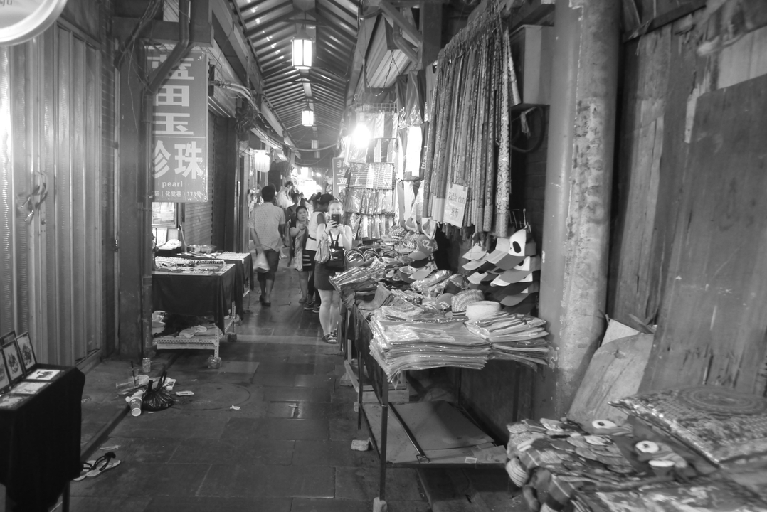 Ruelle du marché couvert avec des étals et des clients.