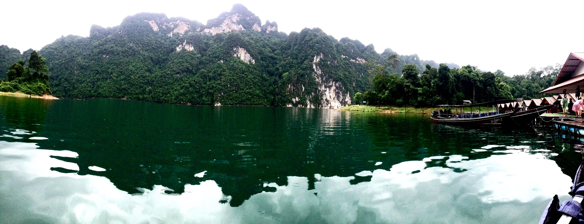 Picturesque lake with forested mountains in the background.