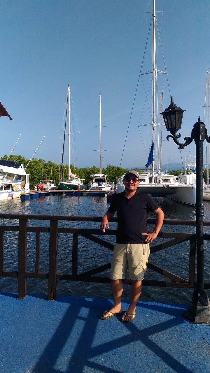 Personne se tenant sur un quai devant des bateaux.