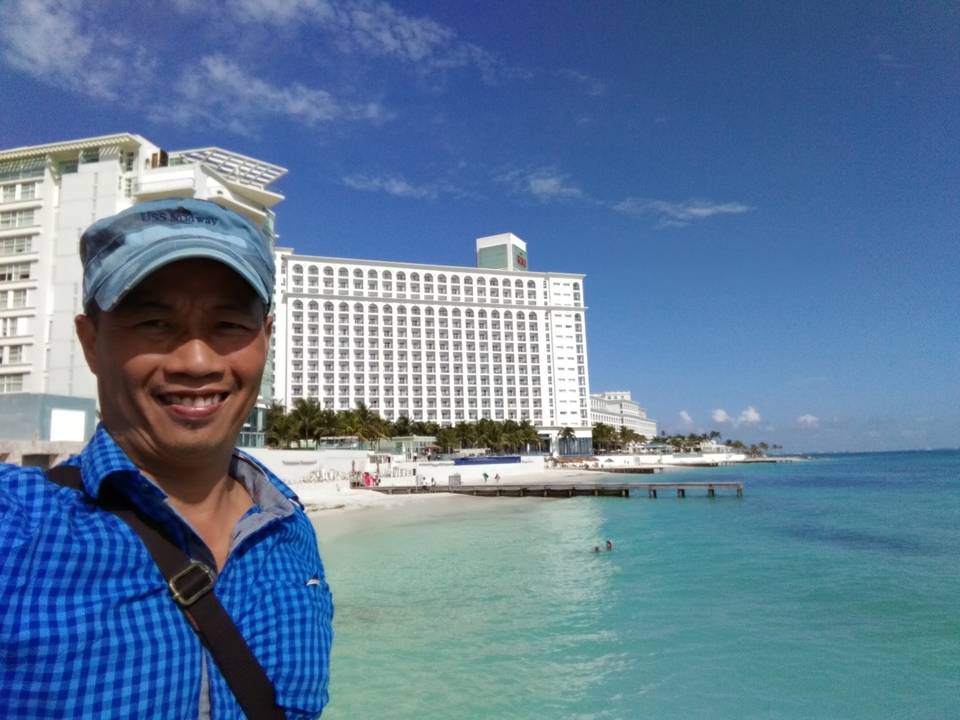 Selfie d'une personne avec une station balnéaire en arrière-plan.