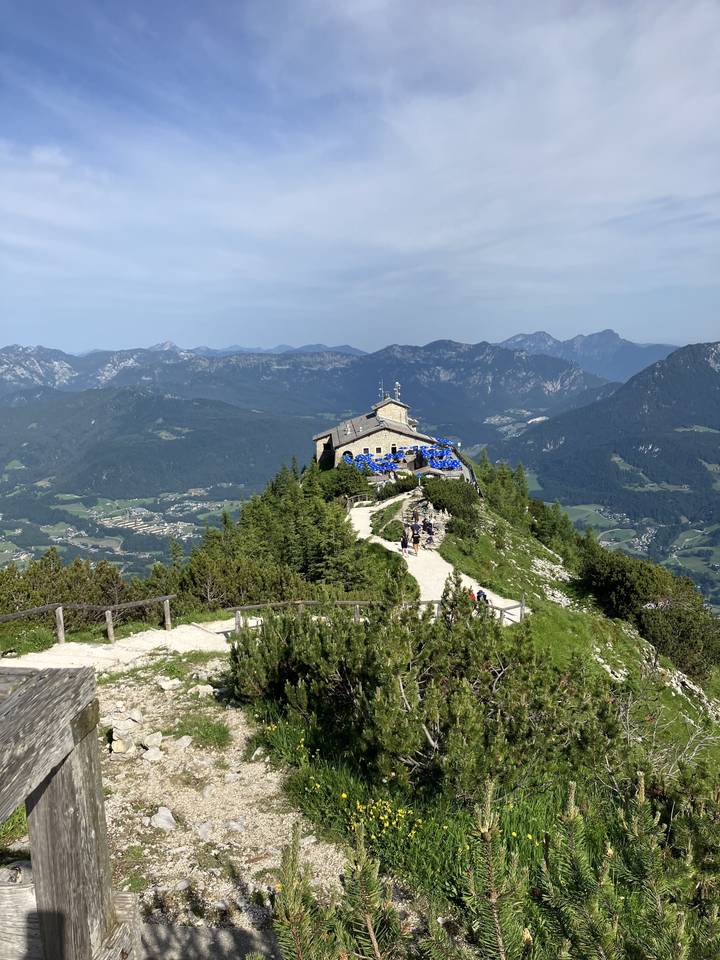 Vue du sommet de la montagne avec une terrasse et des personnes.