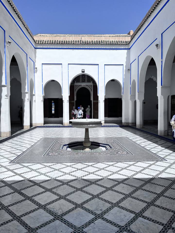 A beautiful courtyard with a fountain and intricate tile patterns.