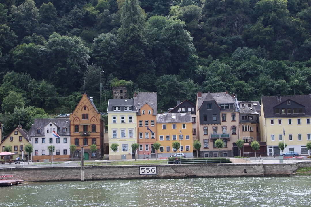 Colorful buildings lining a riverside in a quaint town.