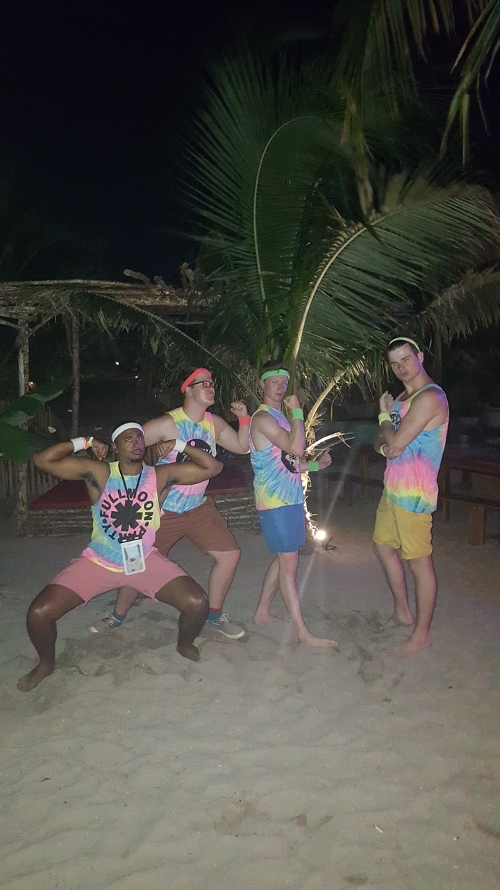 Group wearing colorful shirts at a party under moonlight.