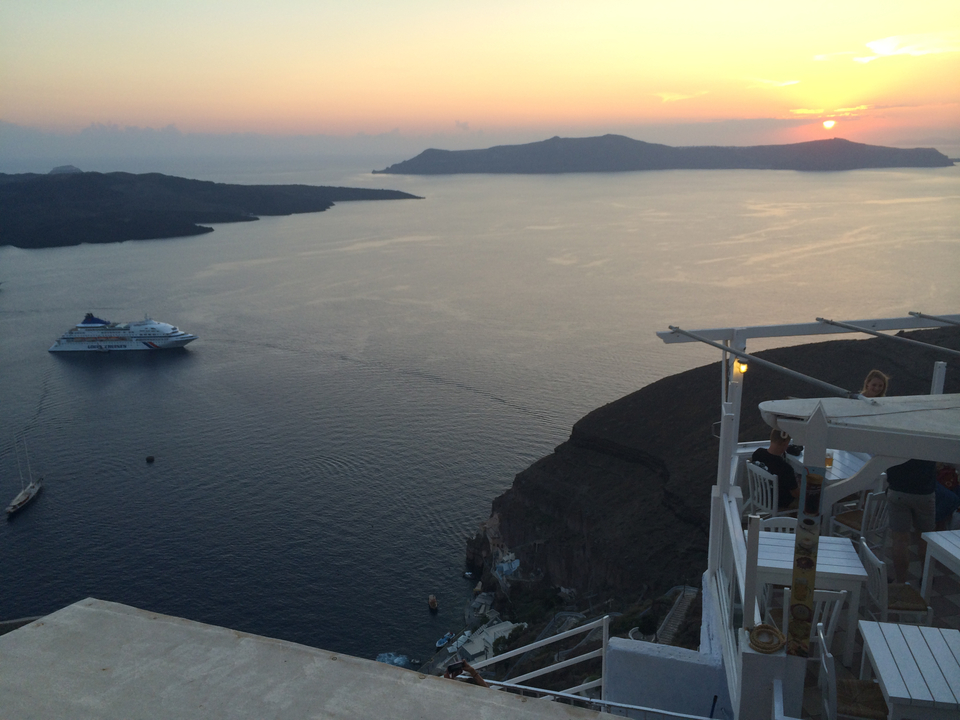 Coastline and islands with a ship during sunset.