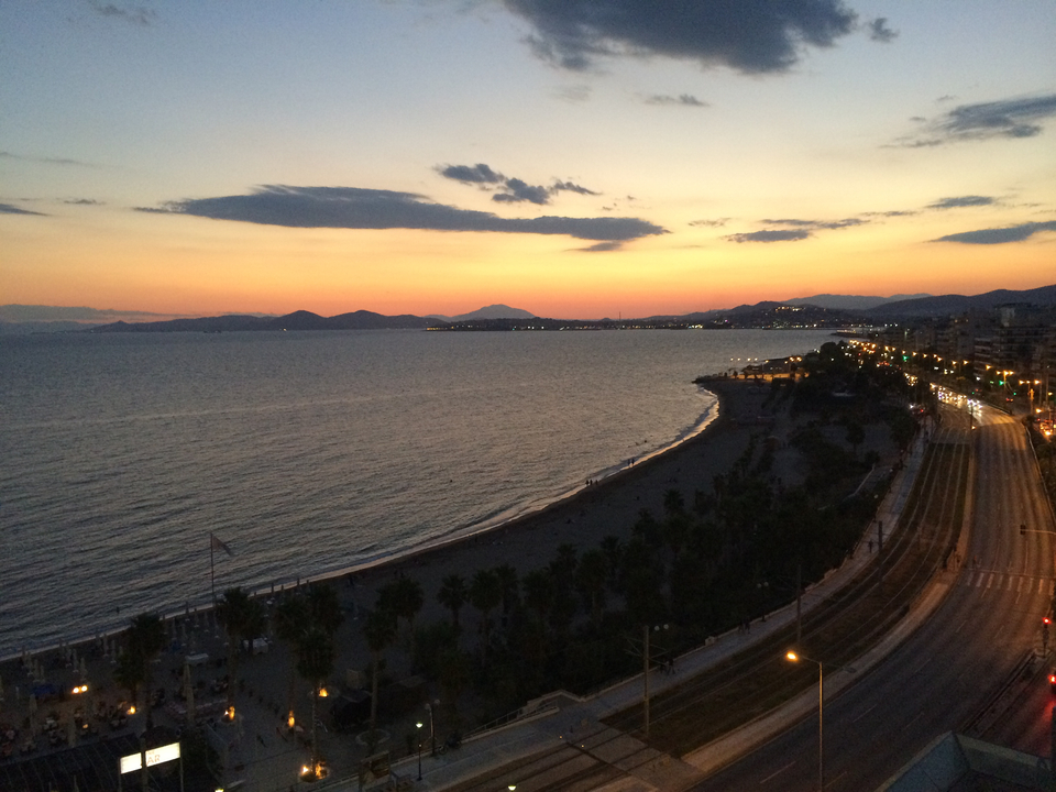Coastal landscape during sunset with city lights.