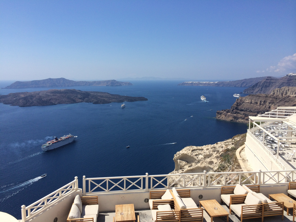 High view of blue sea with white cruise ships and islands.