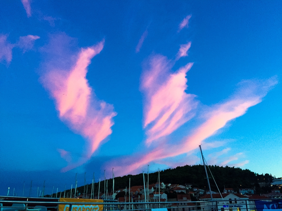 Pink clouds during sunset with a hint of masts below.